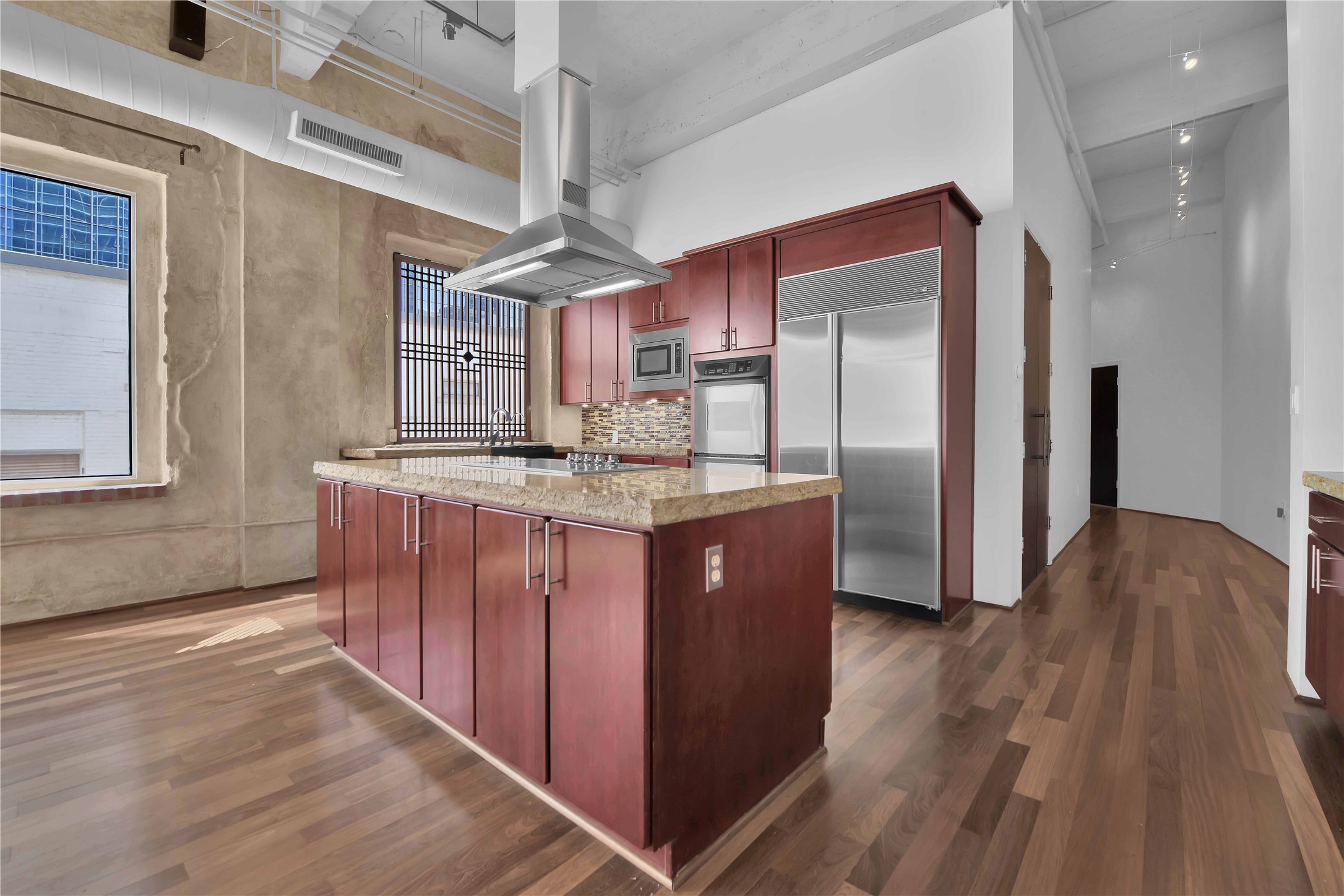 711 Main Street, Unit PH 1003 Houston, TX 77002 - Photo 5 of 32 Cherry cabinets, cook top in island, built in sub zero refrigerator, double oven and chiseled edge granite countertops highlight kitchen.