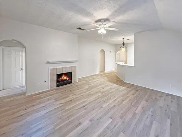 a view of empty room with wooden floor and fireplace