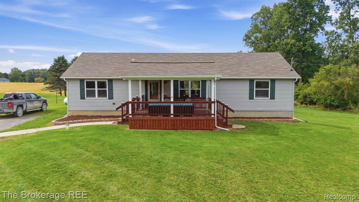 2422 South Henderson Road Davison, MI 48423 - Photo 1 of 53 Ranch-style residence featuring light gray siding, a covered front porch, dark wood-tone decking, green window shutters, and a well-maintained lawn