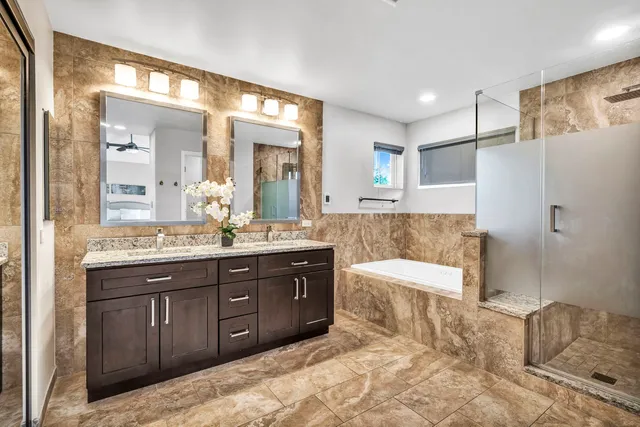 a spacious bathroom with a tub sink and mirror