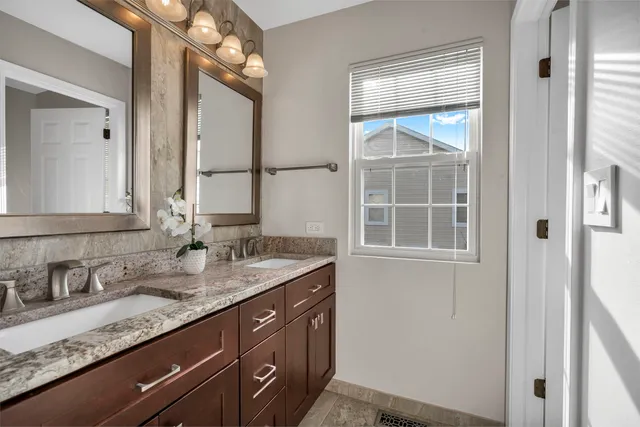 a bathroom with a granite countertop sink and a mirror