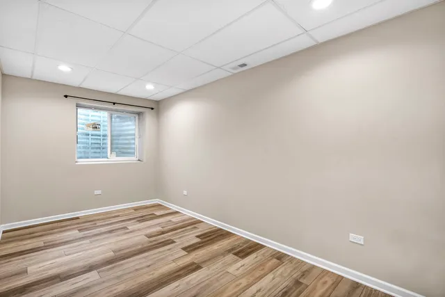 a view of a big room with wooden floor and windows