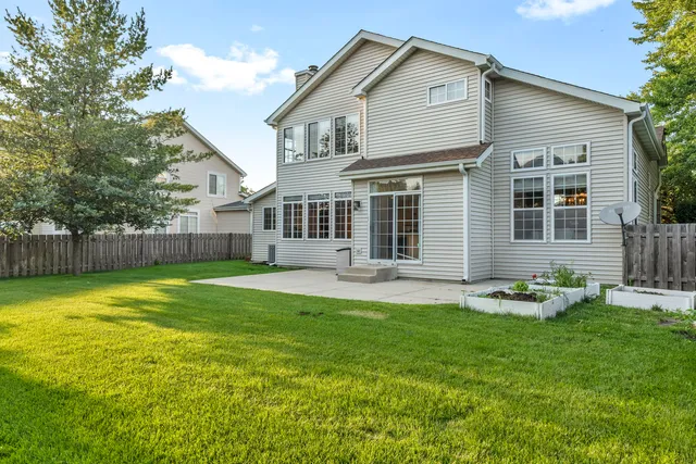 a backyard of a house with table and chairs