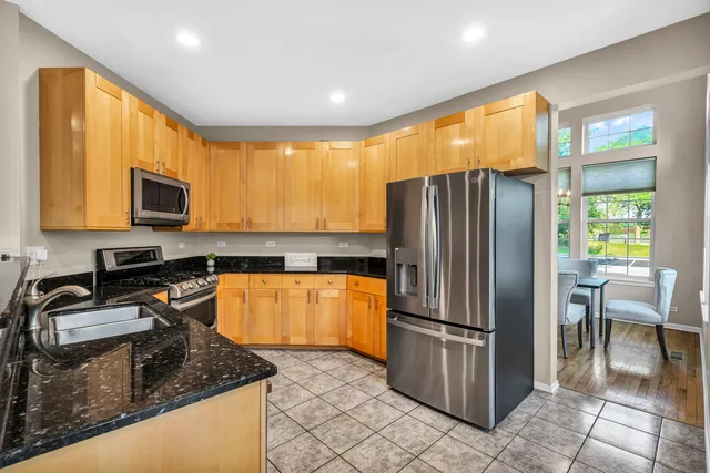 a kitchen with granite countertop a refrigerator stove and sink
