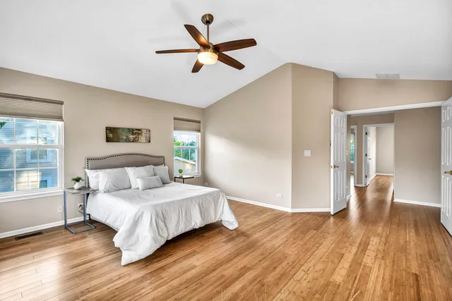 a bedroom with a large bed chandelier and a window