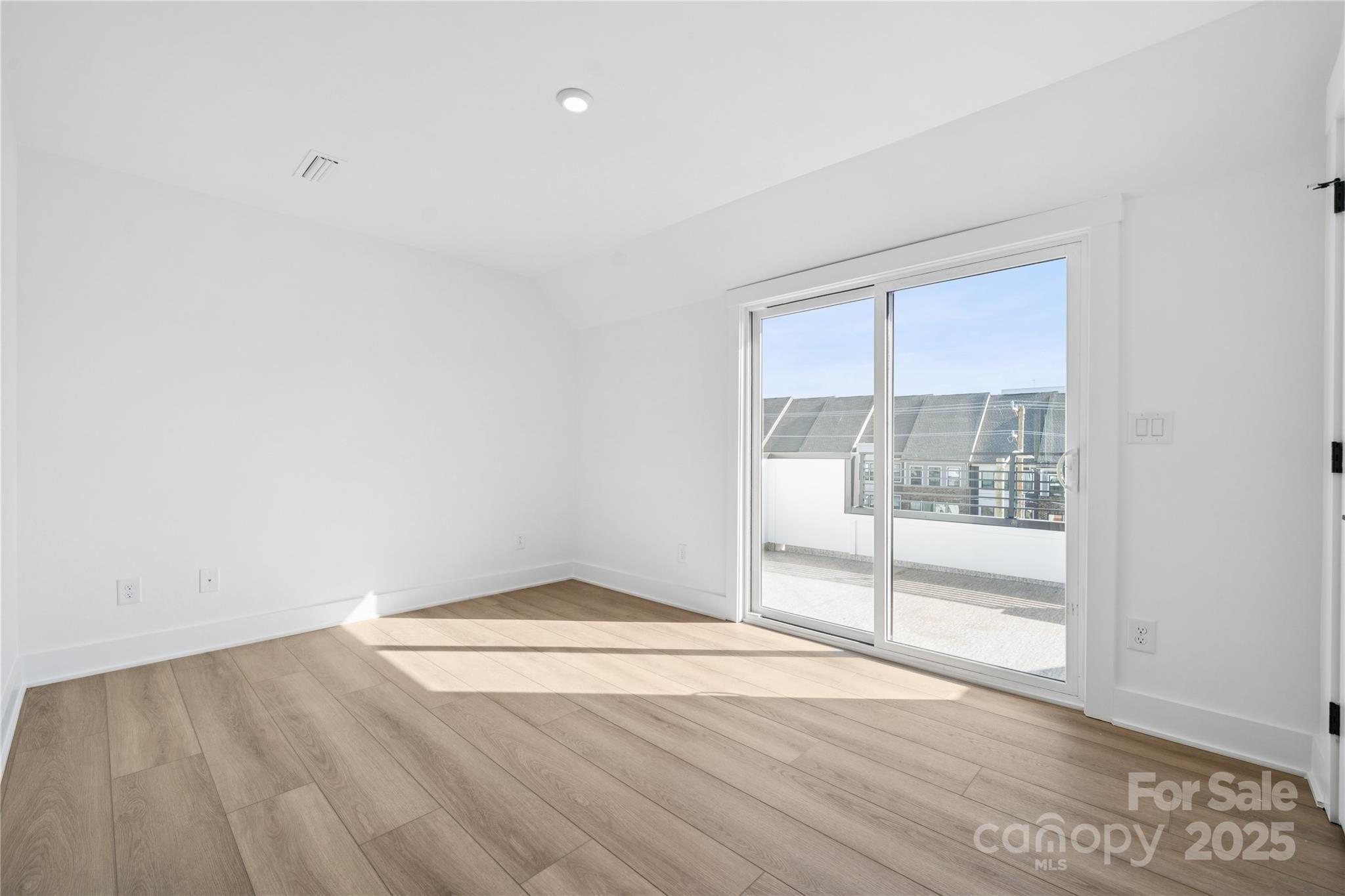 3640 South Tryon Street, Unit 24 Charlotte, NC 28217 - Photo 17 of 25 an empty room with wooden floor and windows