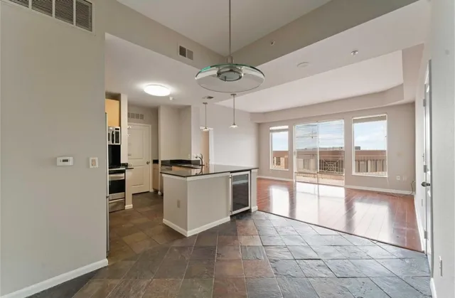 a kitchen with granite countertop a stove a sink and a refrigerator