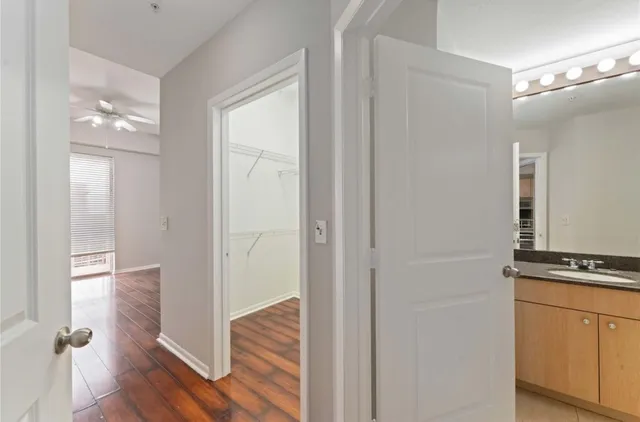 a view of a hallway with wooden floor and cabinet