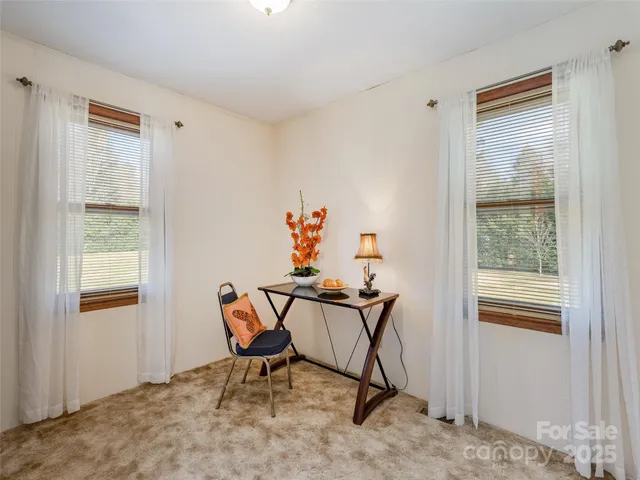 a view of a workspace with furniture and a window