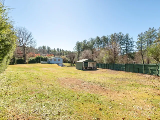 a house view with swimming pool and wooden fence