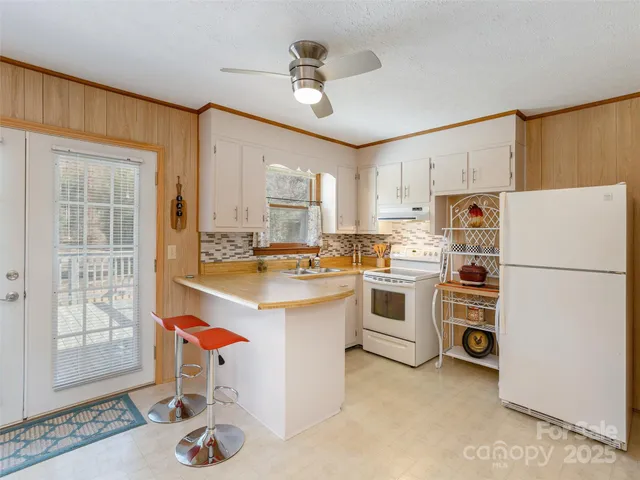 a kitchen with a refrigerator a stove a sink and cabinets