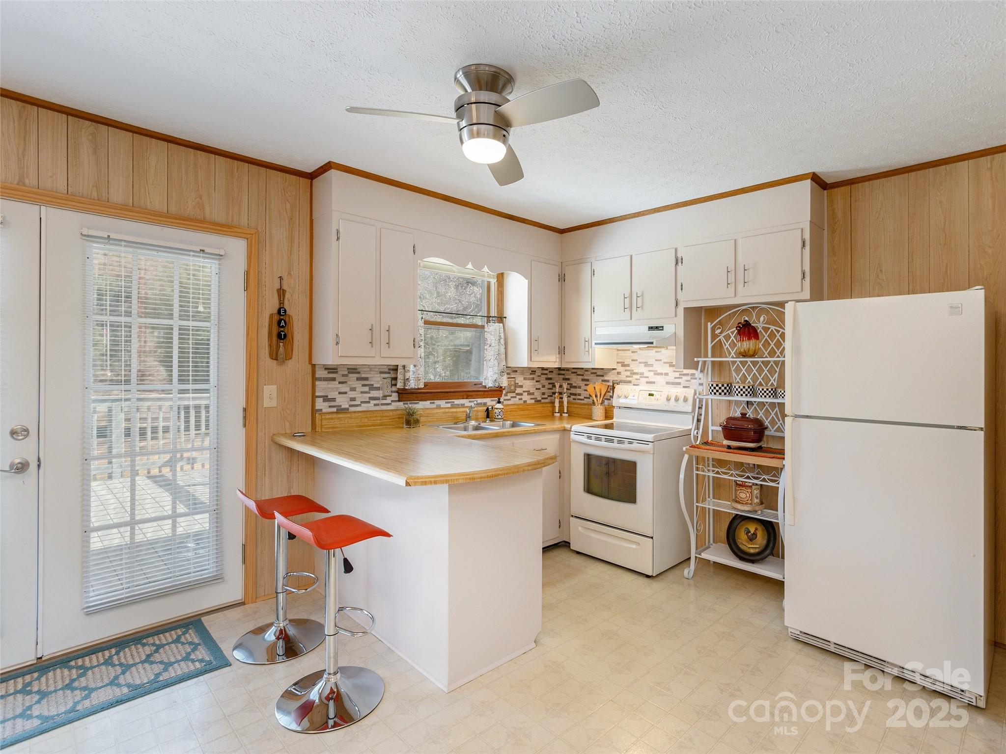 3021 Kanuga Road Hendersonville, NC 28739 - Photo 7 of 24 a kitchen with a refrigerator a stove a sink and cabinets