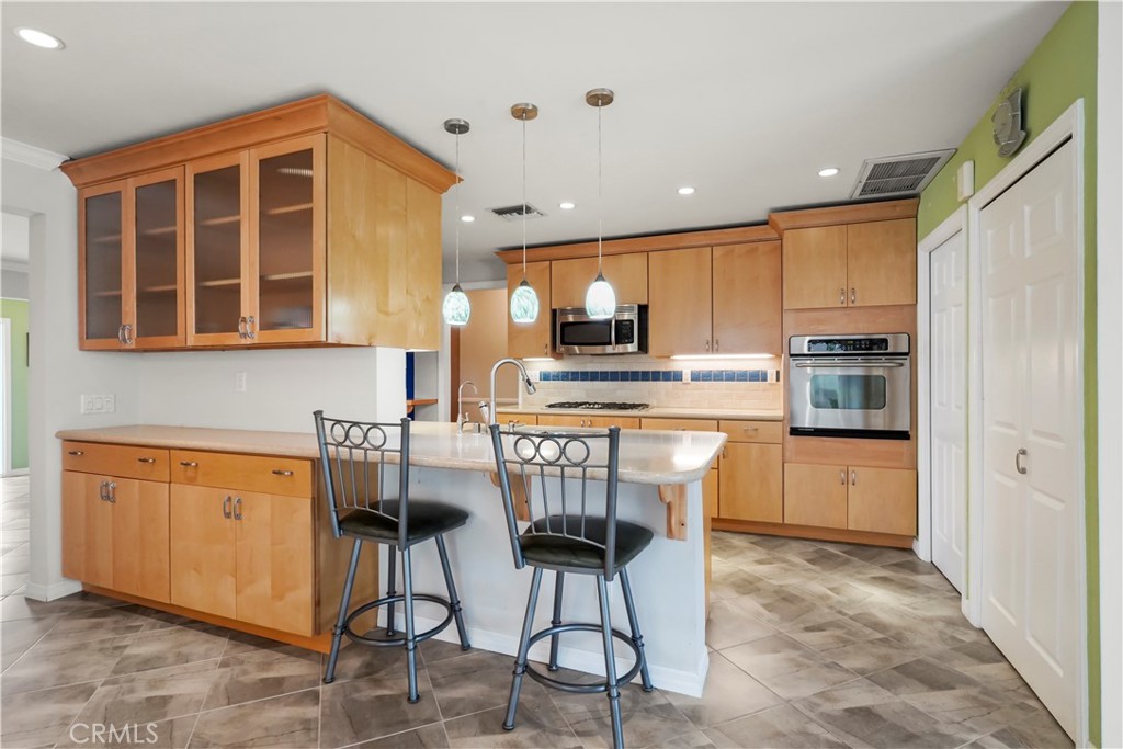 17068 Celtic Street Granada Hills, CA 91344 - Photo 7 of 21 a kitchen with stainless steel appliances granite countertop a stove top oven a refrigerator a kitchen island and chairs