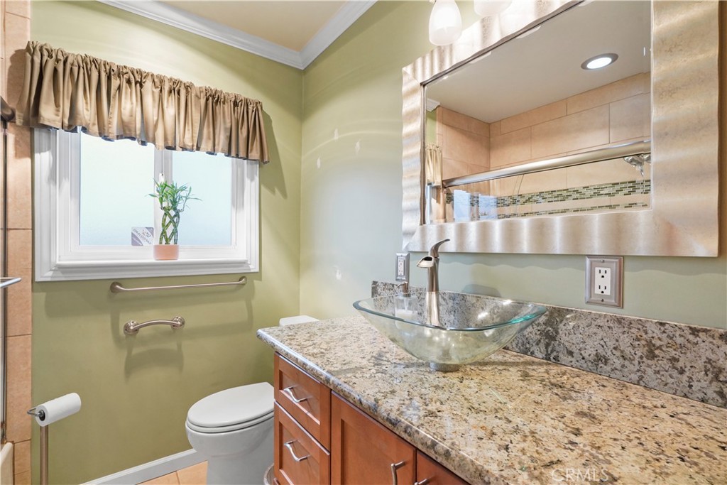 17068 Celtic Street Granada Hills, CA 91344 - Photo 10 of 21 a bathroom with a granite countertop sink a toilet and a mirror