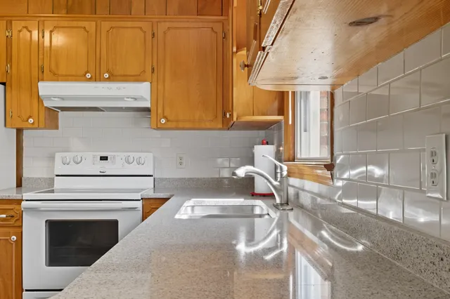 a kitchen with stainless steel appliances granite countertop a sink and a stove