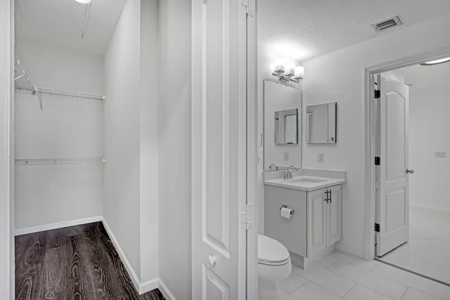 a bathroom with a granite countertop sink a toilet and shower
