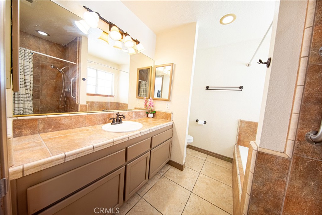14024 Delaware Road Apple Valley, CA 92307 - Photo 17 of 41 a bathroom with a sink a mirror and a bathtub