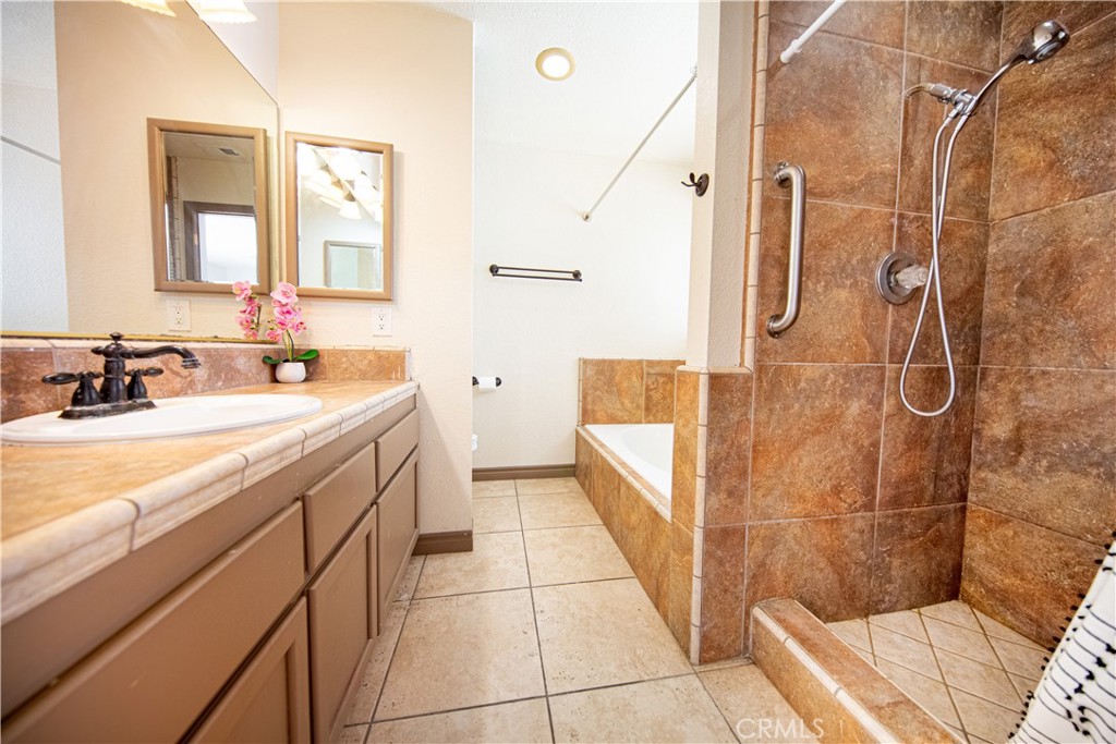 14024 Delaware Road Apple Valley, CA 92307 - Photo 18 of 41 a bathroom with a sink a mirror and a shower