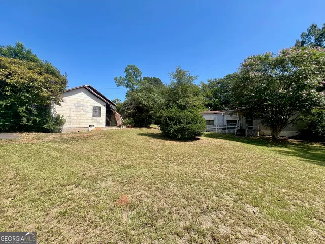 a backyard of a house with plants and trees