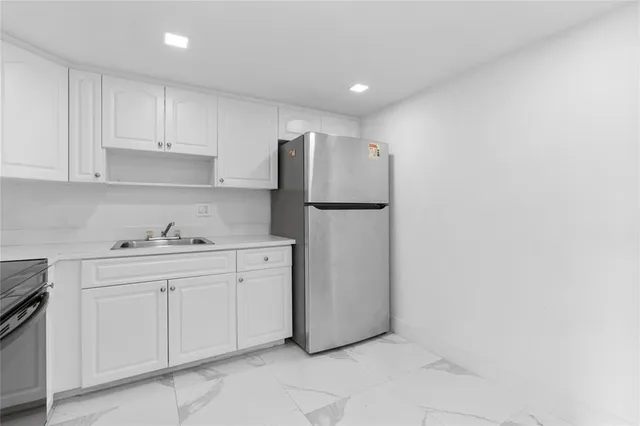 a kitchen with white cabinets and white appliances