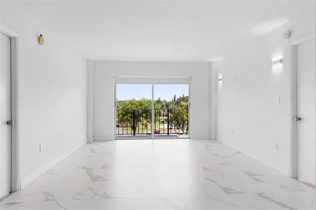 an empty room with windows and outdoor view
