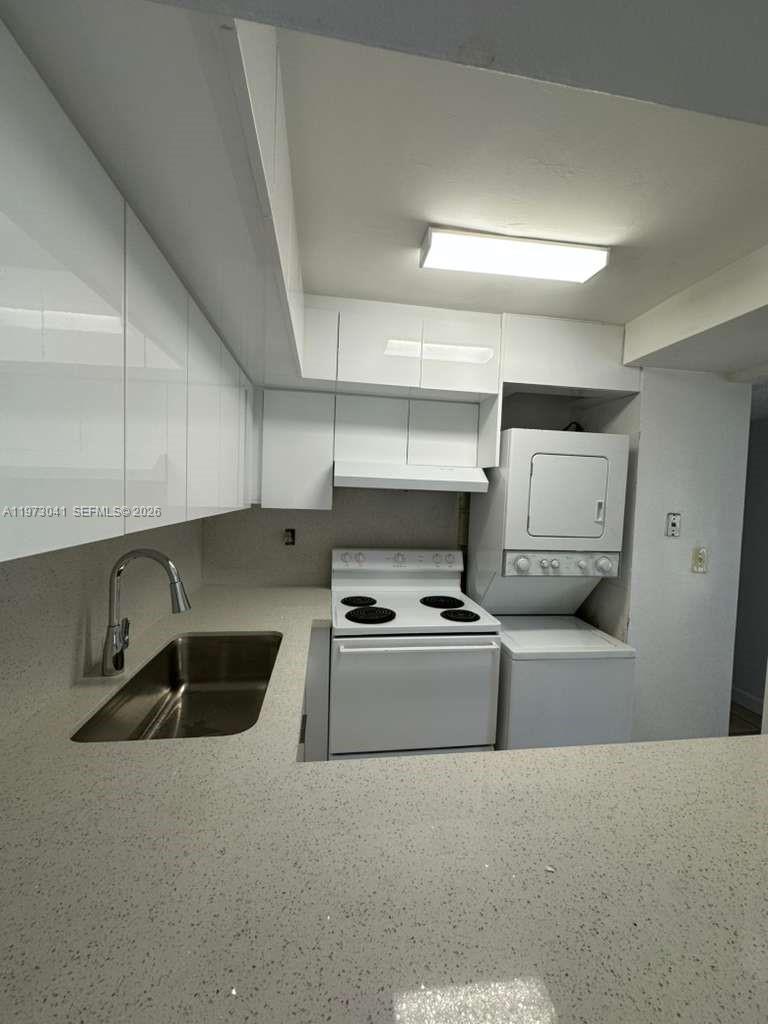 13810 Southwest 112th Street, Unit 110 Miami, FL 33186 - Photo 3 of 11 a kitchen with stainless steel appliances granite countertop a sink and a stove