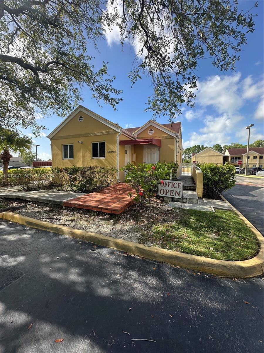 13810 Southwest 112th Street, Unit 110 Miami, FL 33186 - Photo 8 of 11 a front view of a house with garden