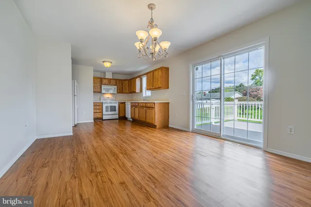 a view of a room with wooden floor fireplace and a window