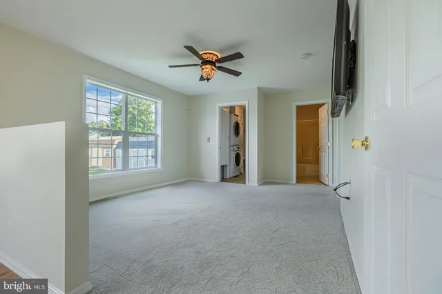 a view of a livingroom with a ceiling fan and window