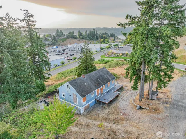 an aerial view of a house with yard and ocean view