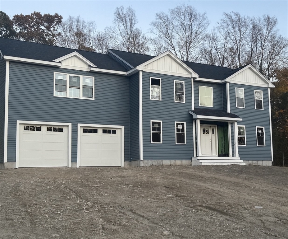 a front view of a house with yard and garage
