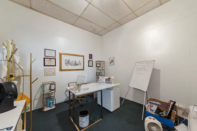 a view of a workspace with furniture and a window