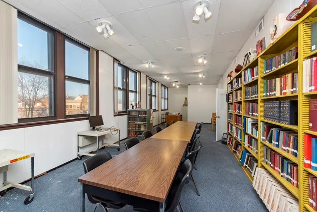 a room with furniture a bookshelf and a window
