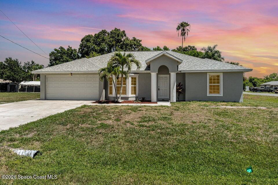 2595 3rd Avenue Northeast Palm Bay, FL 32905 - Photo 1 of 17 a front view of a house with a yard and garage