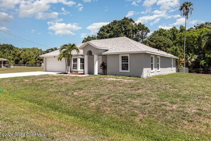 2595 3rd Avenue Northeast Palm Bay, FL 32905 - Photo 2 of 17 a front view of a house with a garden