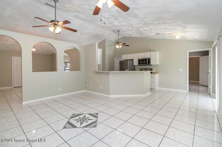 2595 3rd Avenue Northeast Palm Bay, FL 32905 - Photo 3 of 17 an empty room with kitchen and chandelier fan