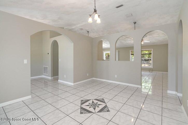2595 3rd Avenue Northeast Palm Bay, FL 32905 - Photo 5 of 17 an empty room with chandelier and glass door