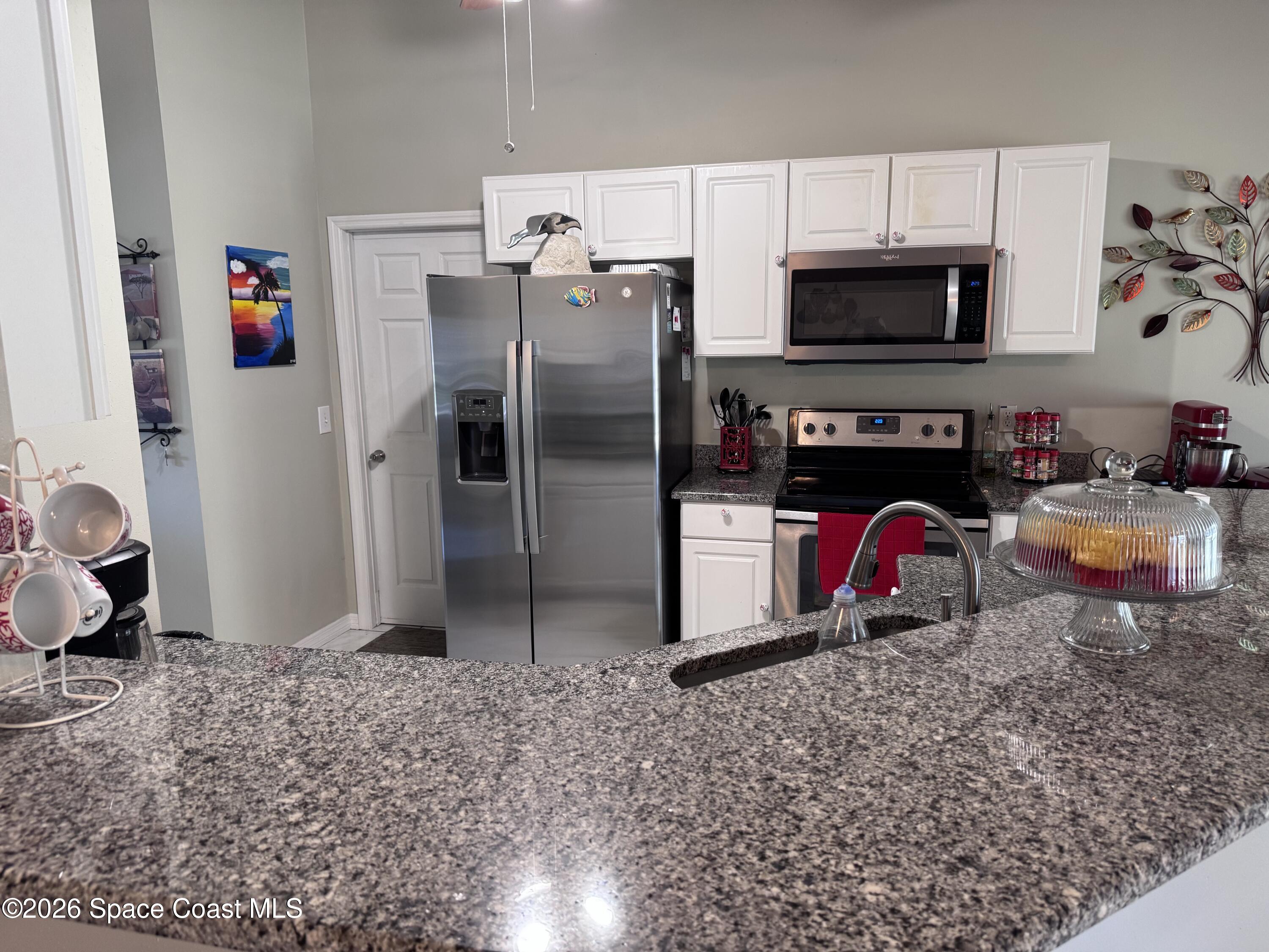 2595 3rd Avenue Northeast Palm Bay, FL 32905 - Photo 6 of 17 a kitchen with stainless steel appliances granite countertop a refrigerator stove and sink