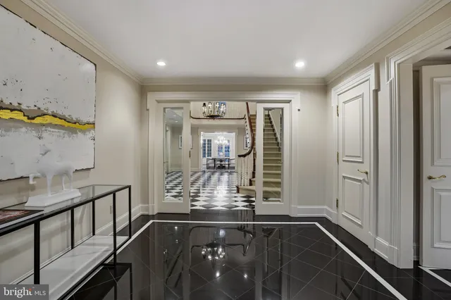 a view of a hallway with windows and chandelier