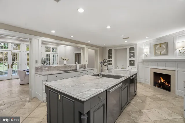 a large white kitchen with a sink and dishwasher