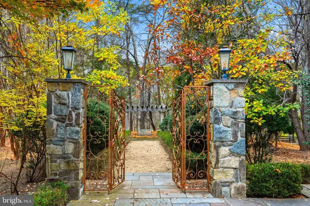 a front view of a house with a garden and trees