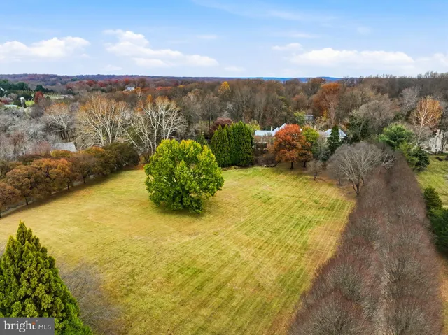 an aerial view of residential houses with outdoor space and lake view