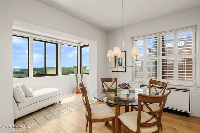 a dining room with furniture and large windows