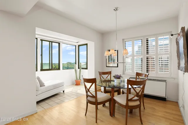 a dining room with furniture and large windows
