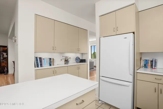 a kitchen with white cabinets and white appliances