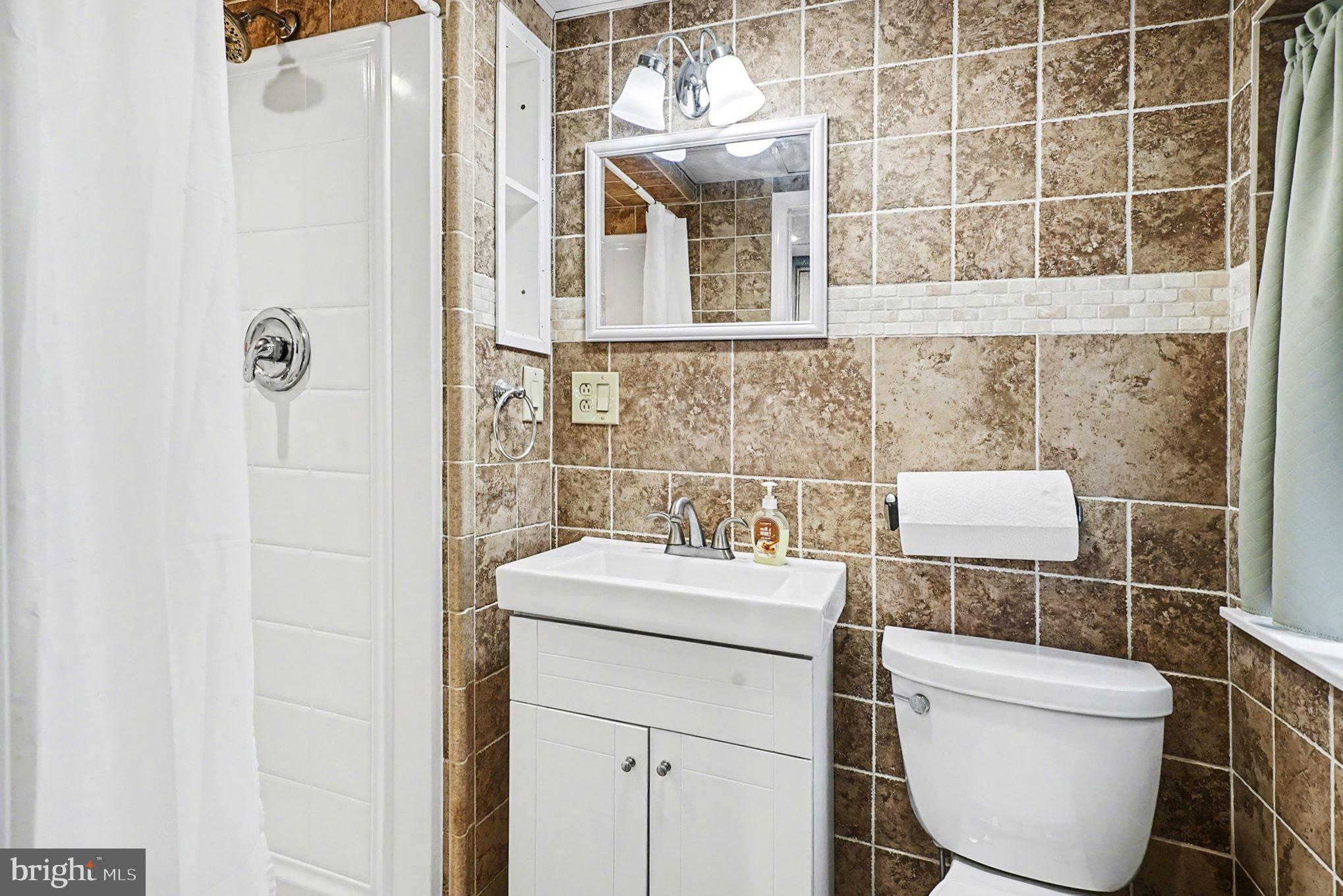 4031 Vernon Road Drexel Hill, PA 19026 - Photo 29 of 38 a bathroom with a toilet sink and mirror