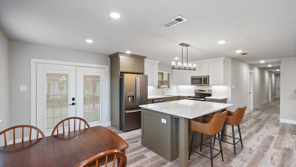 129 King Arthur Road Mabank, TX 75156 - Photo 26 of 33 a kitchen with stainless steel appliances granite countertop a dining table chairs and refrigerator