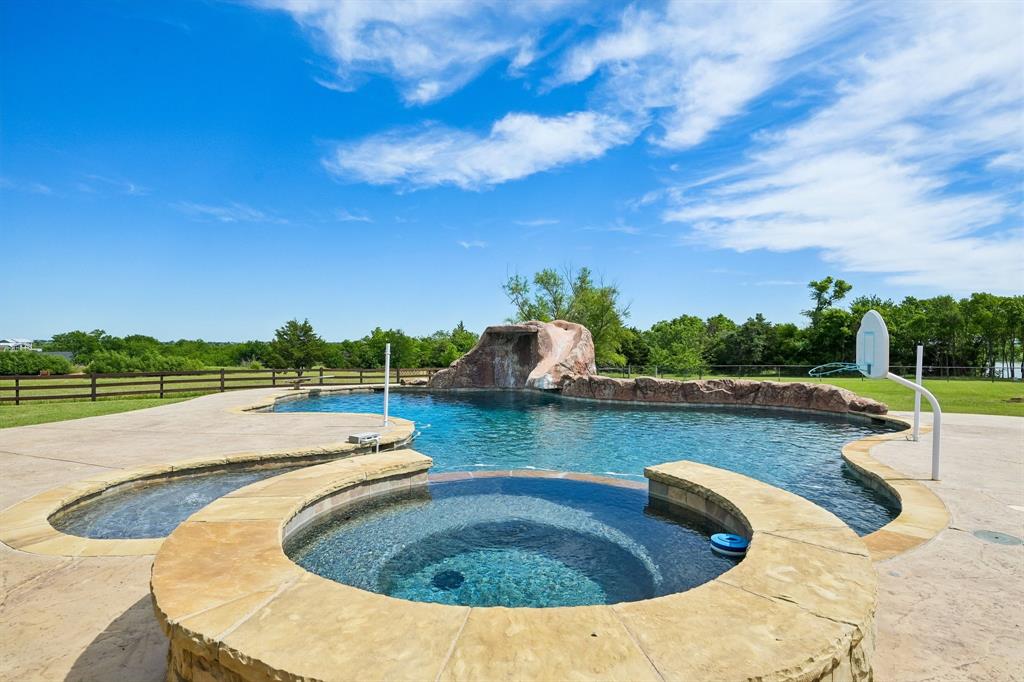2085 Switzer Road Sanger, TX 76266 - Photo 34 of 39 Resort-style pool area featuring a rock waterfall, integrated spa, and expansive concrete decking