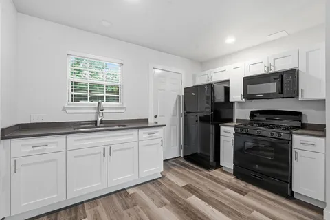 a kitchen with stainless steel appliances granite countertop a stove a sink and a refrigerator