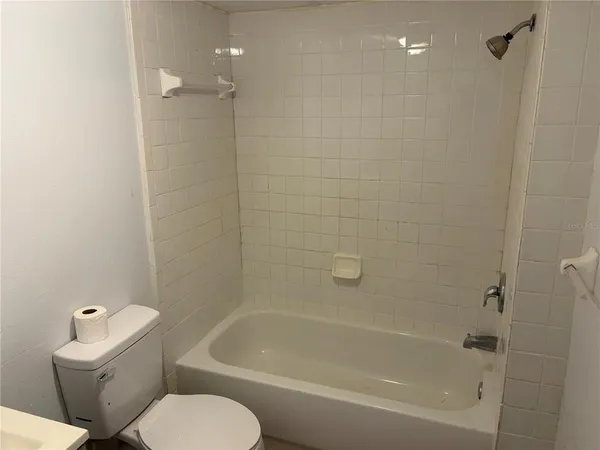 a white toilet sitting next to a bath tub